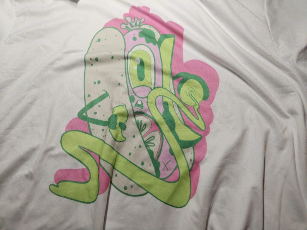 A white graphic t-shirt. An alien, cyclops hot dog looks fearfully at the camera